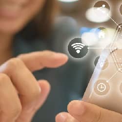 Image show the picture of an office worker using mobile phone technology to access company information.