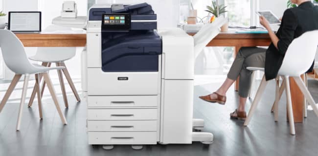 Image shows picture of Xerox VersaLink 7100 Series Multifunction Color Printer, MFP, in an office setting.